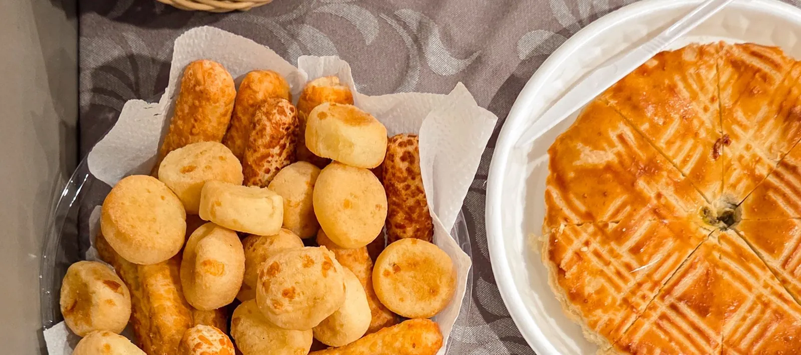 Salgados e tortas assadas, típicos de padaria brasileira, dispostos numa mesa.